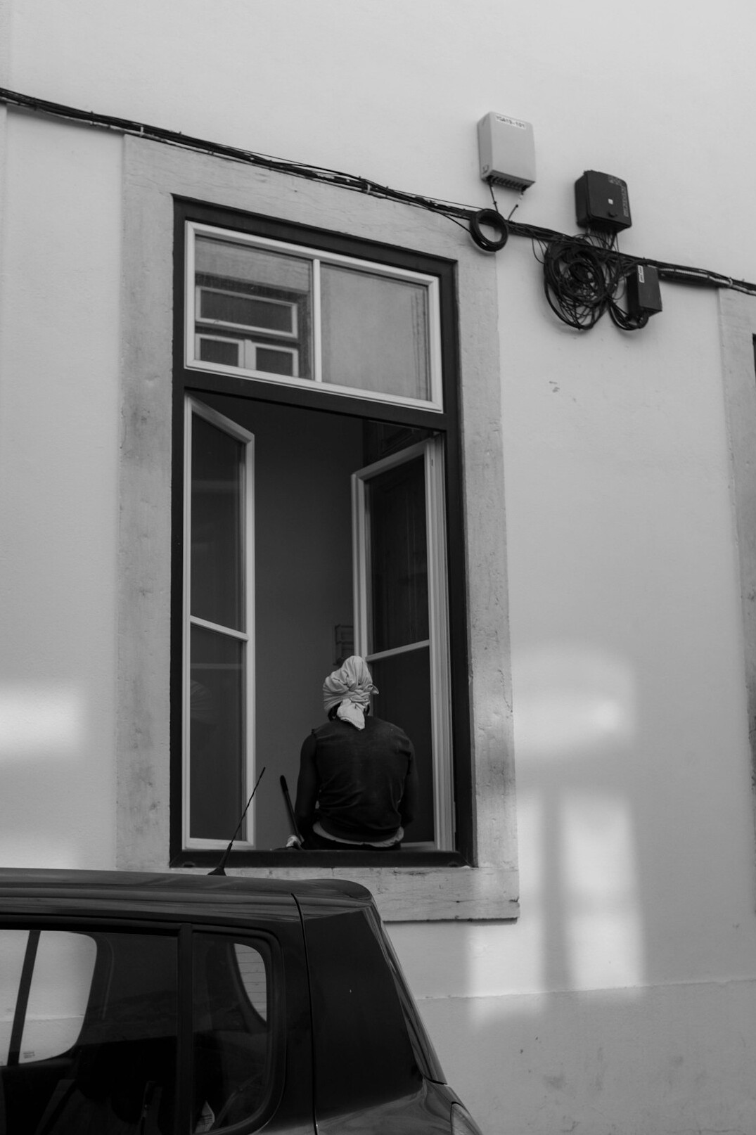 person looking out window at street