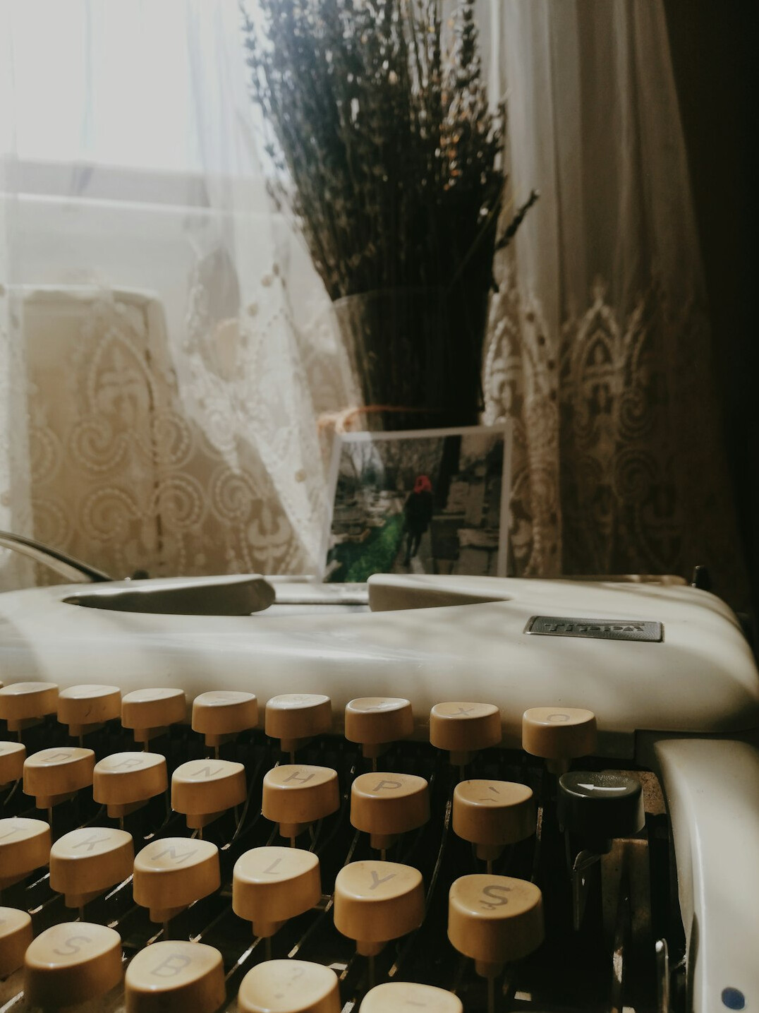 Vintage typewriter on a wooden desk with notebook and coffee cup in low light